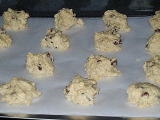 cookie dough dropped into round balls onto a cookie sheet with wax paper over it 