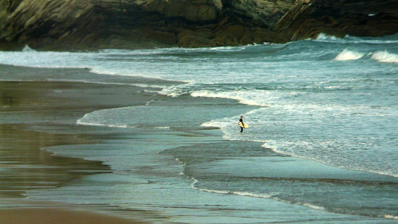 surfista entrando al agua sopelana