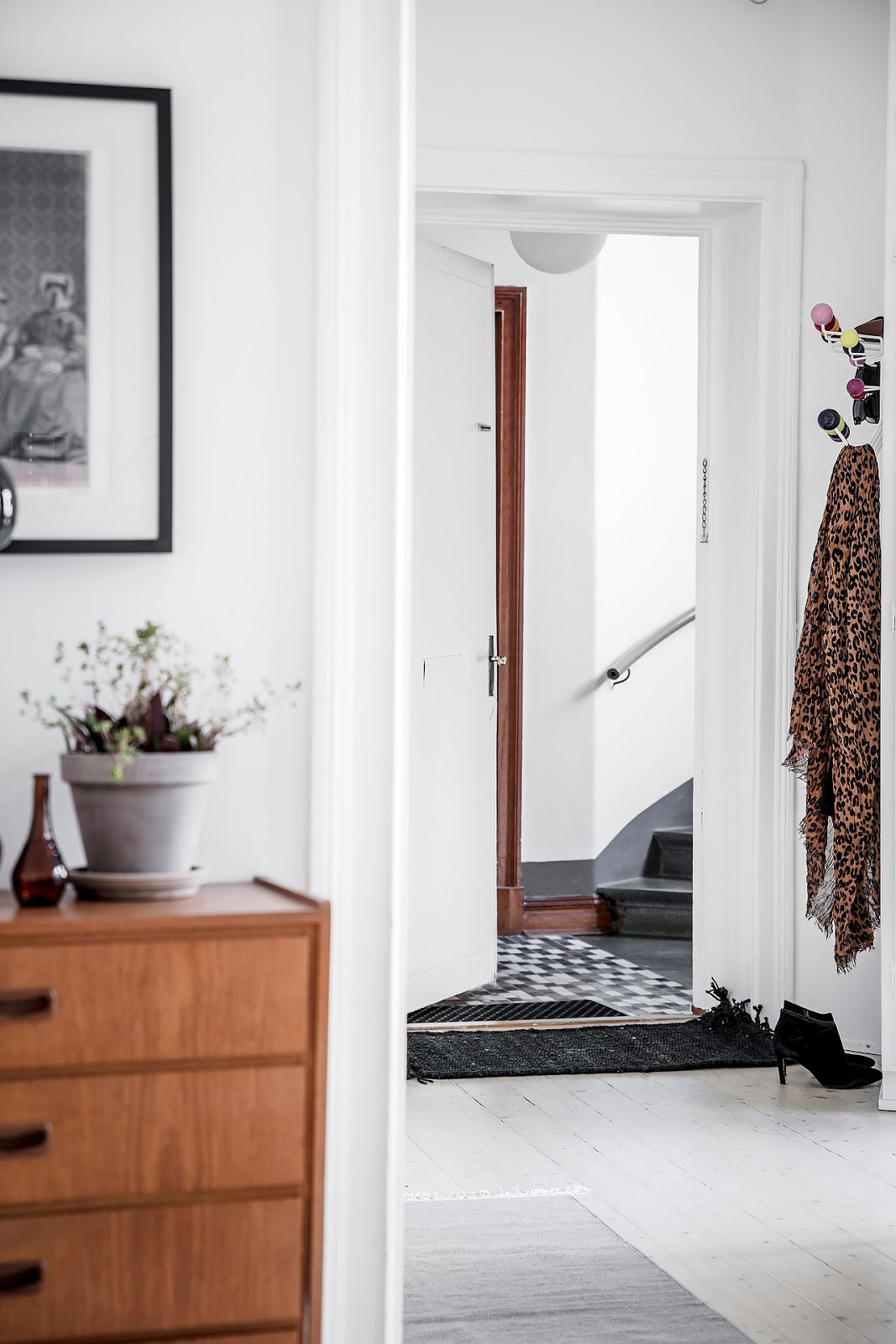 White scandinavian apartment with nice wall art, danish modern chest and IKEA sofa