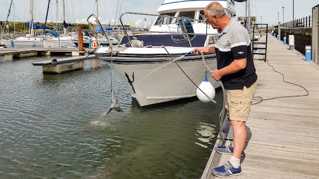 Washing the anchor after we tested it by dropping it in the marina Photo washing the anchor after we tested it by dropping it in the marina