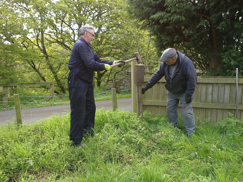 Bill and Malcolm planting a speed limit sign at Causey