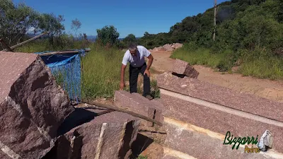 Bizzarri, da Bizzarri Pedras, fazendo o que gosta, garimpando pedras na pedreira. Na foto, escolhendo pedra folheta de granito vermelho, sendo pedras para escada, pedra para caminho no jardim, pedra para banco de pedra, pedra para guia de pedra e pedra para calçamentos.