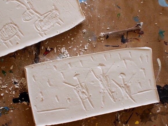 Carve plaster of paris like a rock with a twig