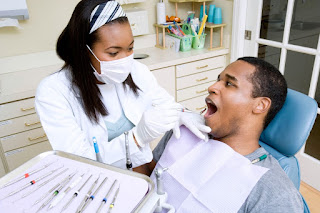 A dentist examining a man's teeth