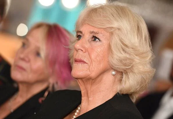The Duchess of Cornwall sports a chic polka dot dress and ultra stylish cape at a reception for National Literacy Trust