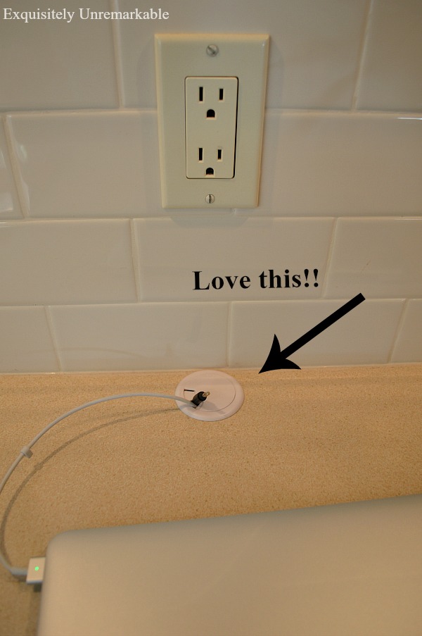 Cable grommet installed on desk with arrow pointing to it that says love this