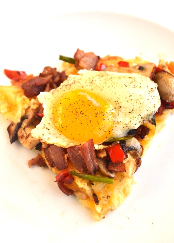 Breakfast Pizza with Hash Brown Crust has a crispy, cheesy hash brown crust and is topped with , eggs, bacon, melted cheddar cheese, and sauteed mushrooms, asparagus and peppers! www.nutritionistreviews.com