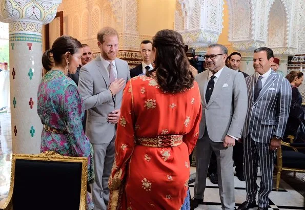 Meghan Markle wore Carolina Herrera floral printed silk chiffon short sleeve gown, and she carries Dior Bee embellished clutch