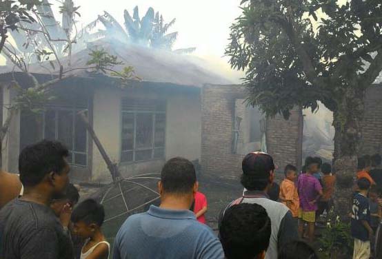 Warga menyaksikan rumah yang terbakar. Warga menyaksikan rumah yang terbakar.