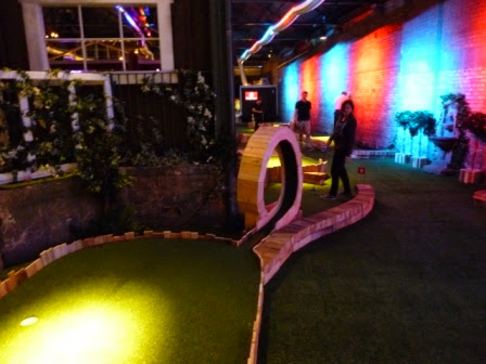 Emily playing the loop-di-loop hole at Swingers Crazy Golf course in London Swingers Crazy Golf in Shoreditch, London