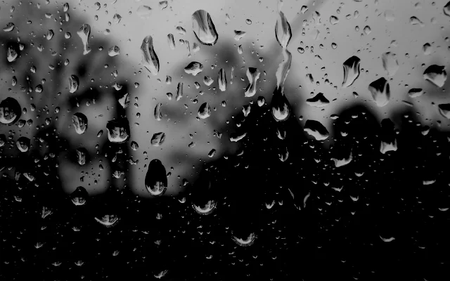 Slecht weer met regendruppels op het raam