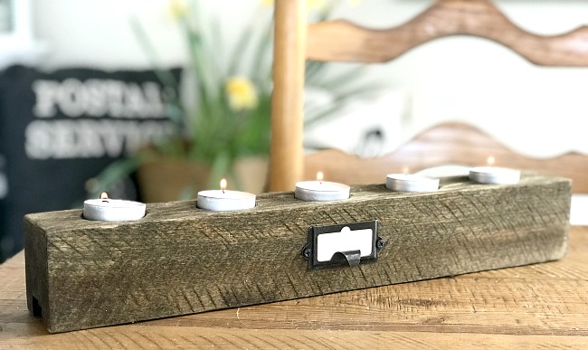 wooden candle holder on table with flowers