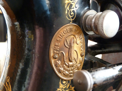 Close up of 1893 Singer badge below stitch length adjuster