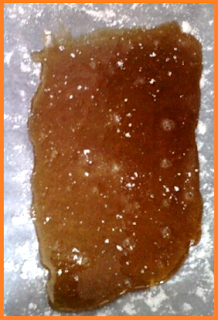 thin coating of mixture on parchment paper.  A dusting of powdered sugar is visible.