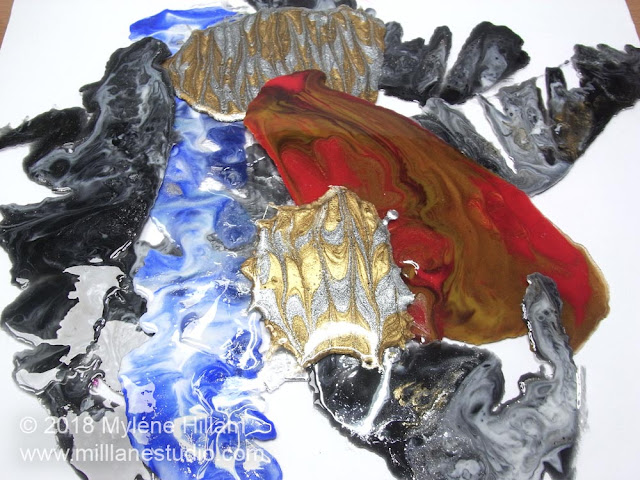 Red, blue, black and gold marbled over-flow from resin paintings.