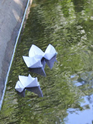 folded paper boats floating in water