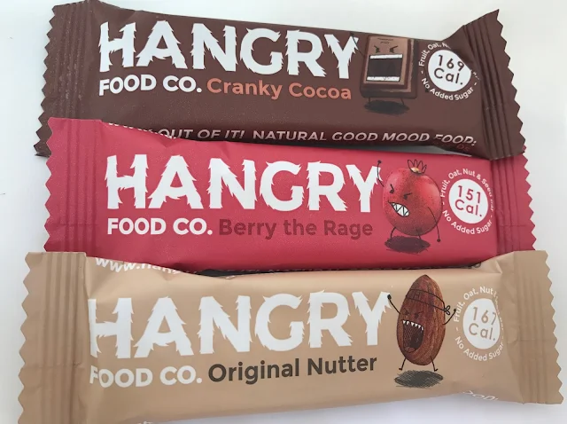 3 Hangry food co. bars: a brown one in cranky cocoa, a red one in berry the rage and a beige one in original nutter