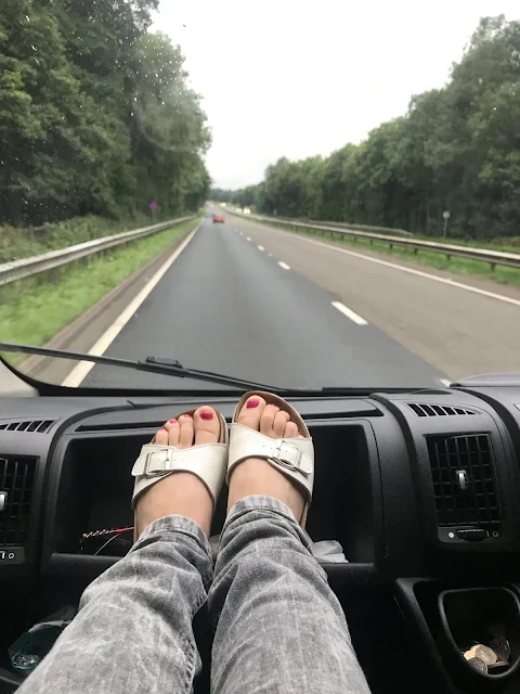woman feet in sandel on dashboard of van