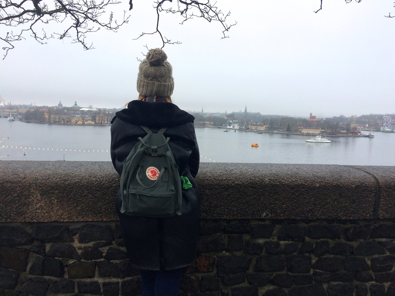 Explorer stood by the river in Stockholm with Kanken backpack