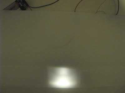 Light shining behind a white plastic folder.