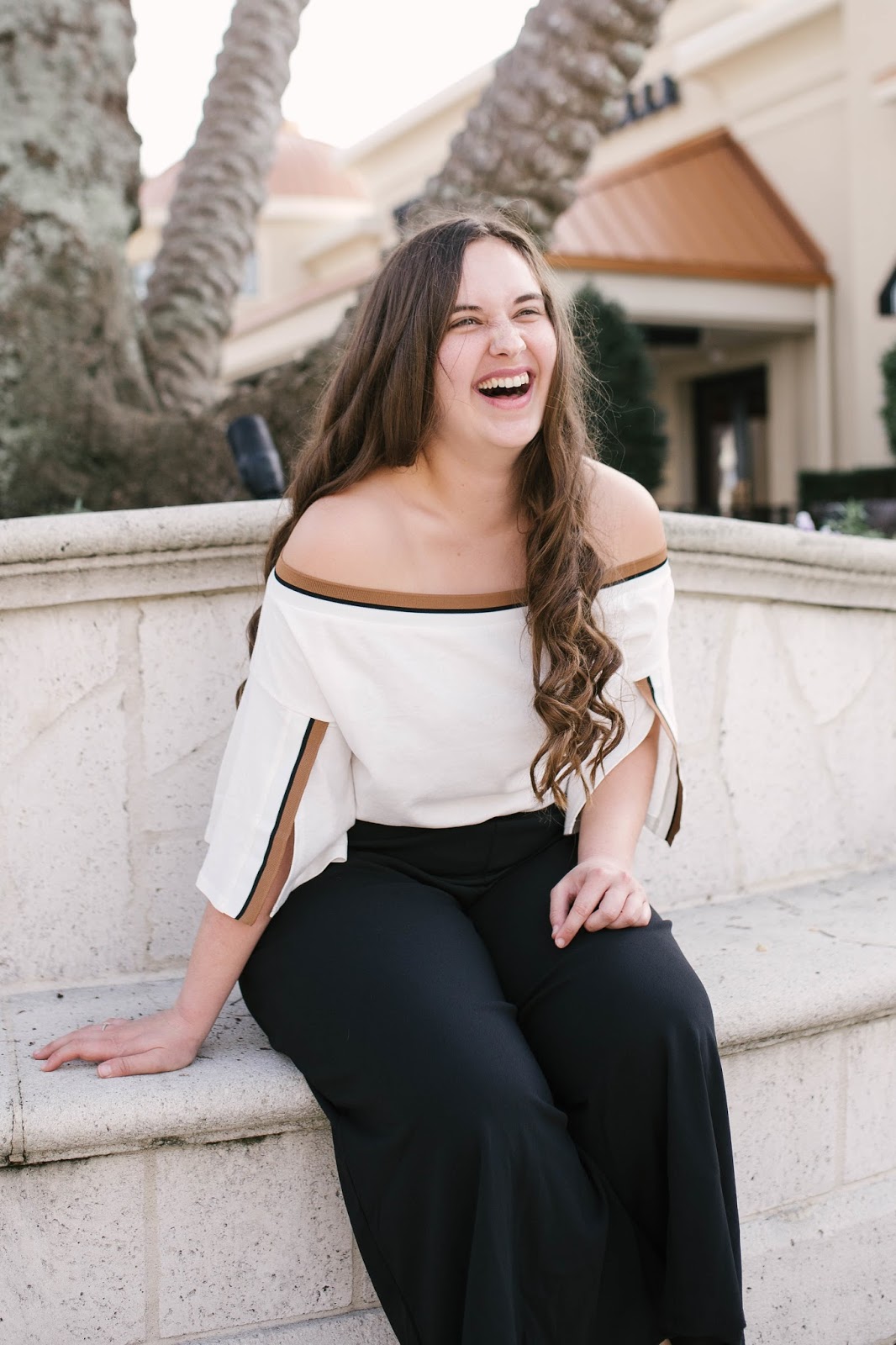 Girl wearing black culotte pants and off the shoulder top