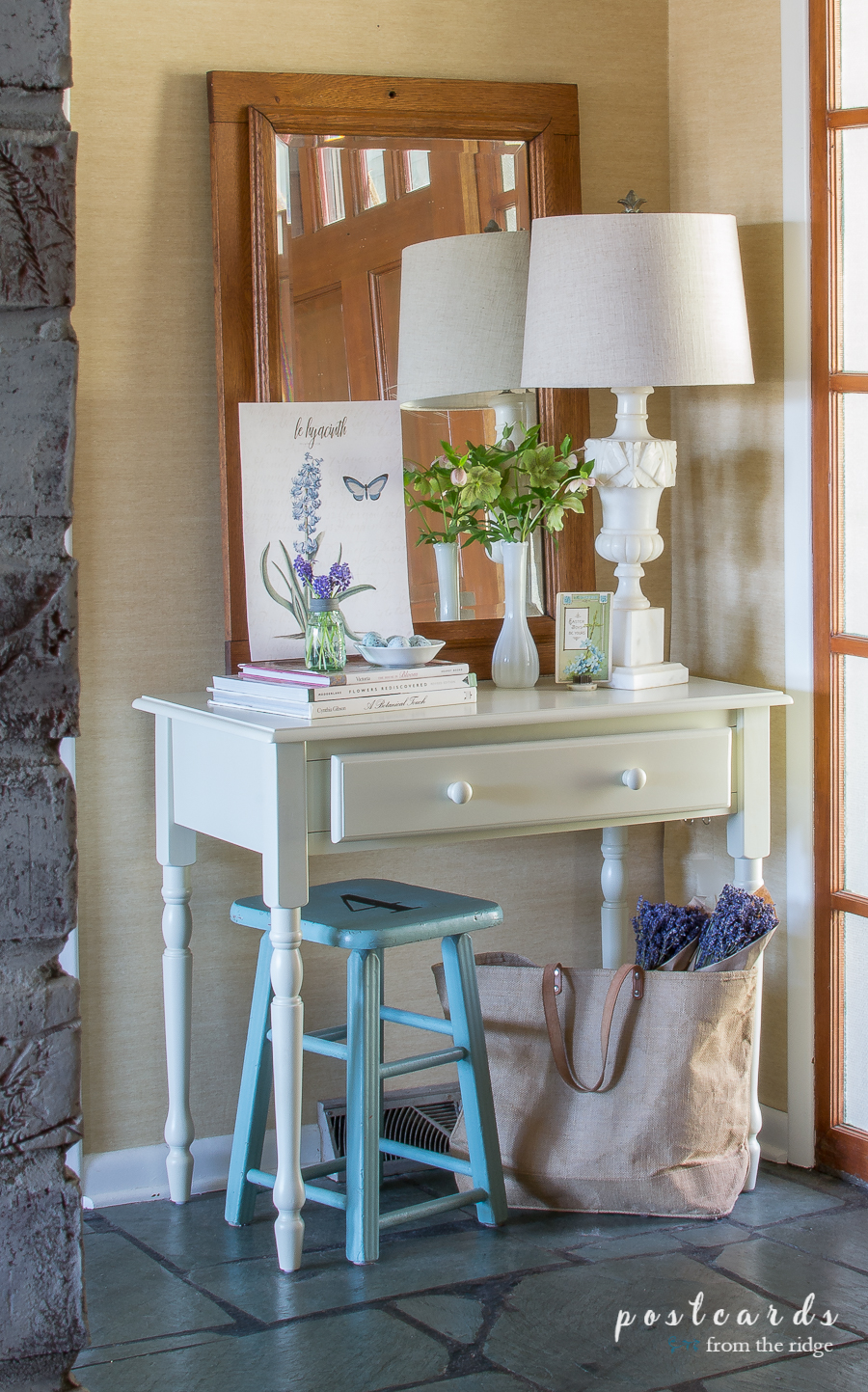blue stool and white desk with decor in entry