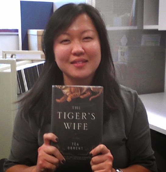 Ms. Chi holding a copy of The Tiger's Wife, a book by Tea Obreht