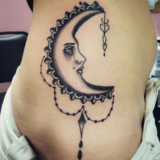 Uma lua crescente é embelezado com contas penduradas.
