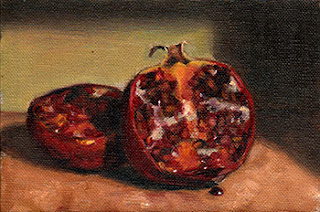Oil painting of a pomegranate cut into halves.