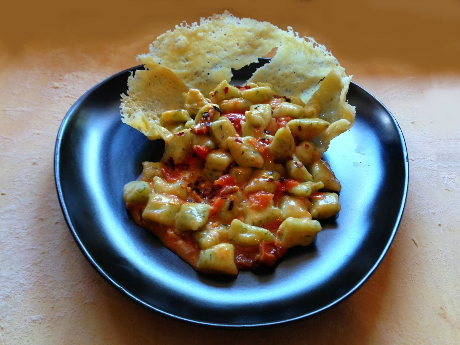 Gnocchetti di rucola con pomodorini pachino, pinoli tostati in cialda croccante di pecorino sardo