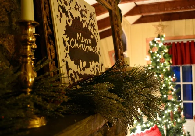 Christmas Mantel decorated with a wooden gift bag sign at night