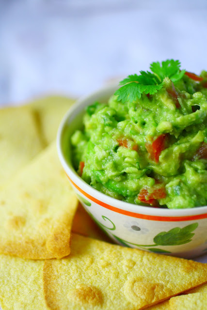 My go-to recipe for fresh, homemade guacamole.  A simple mix of avocado, spring onion, coriander/cilantro, tomato and lime - perfect for dunking chips in, topping a burger with or as a side for brunch.