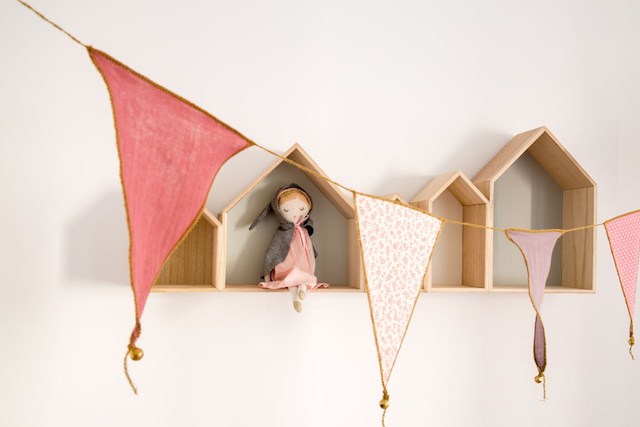 Banderines de tela y casitas de madera decorando un dormitorio infantil 