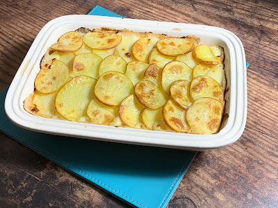 Cooked Garlic Chicken and Leek Potato Bake on a wooden table
