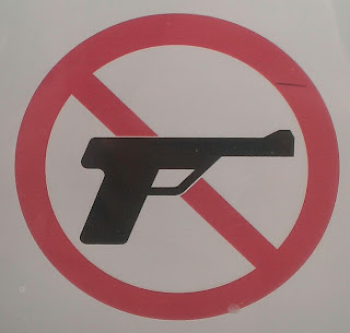 a sign with a red slash through a hand gun