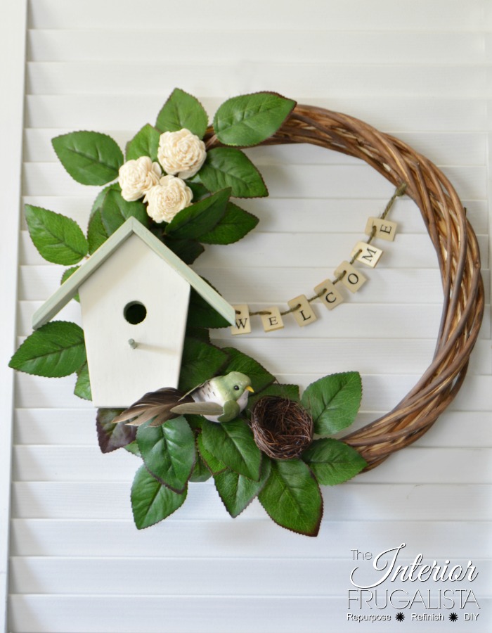 A unique welcoming DIY birdhouse wreath with farmhouse style for Spring And Summer that's easy on the wallet made with thrift store and dollar store finds.