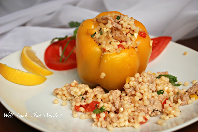 Chicken and Mediterranian Couscous Stuffed Peppers on a white square plate with lemon wedges 