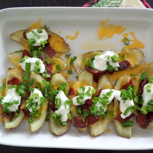 Loaded Baked Potato Skins:  Warm potato skins loaded with cheese, bacon, sour cream, and green onions.  A delicious gameday snack.  #footballsnack