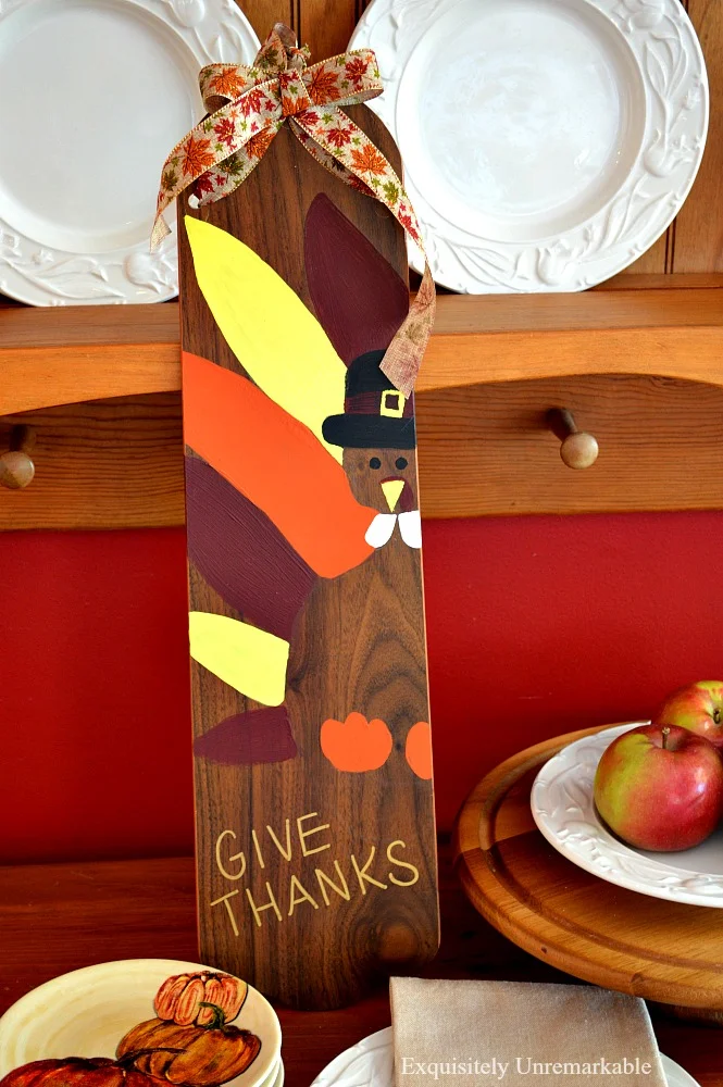 Painted Thanksgiving turkey wooden sign on an old fan blade to welcome the holiday. It's an easy DIY and super cute, too.