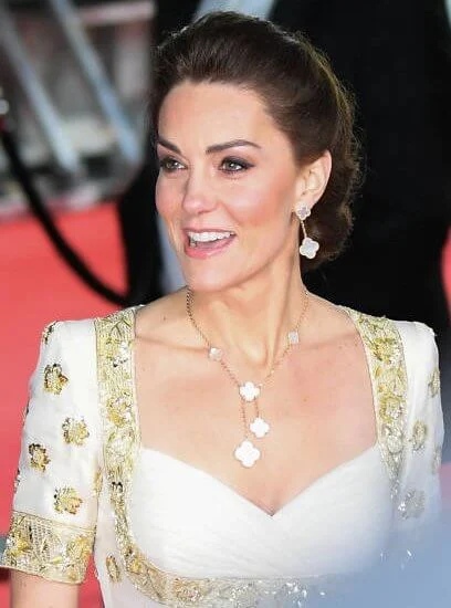 The Duchess wore a gown by Alexander McQueen. Jimmy Choo Romy gold pumps, She carries Anya Hindmarch gold glitter box clutch