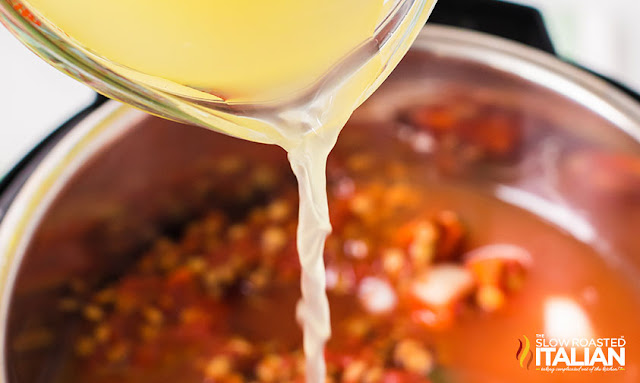 Instant Pot Lentil Soup pouring in chicken stock