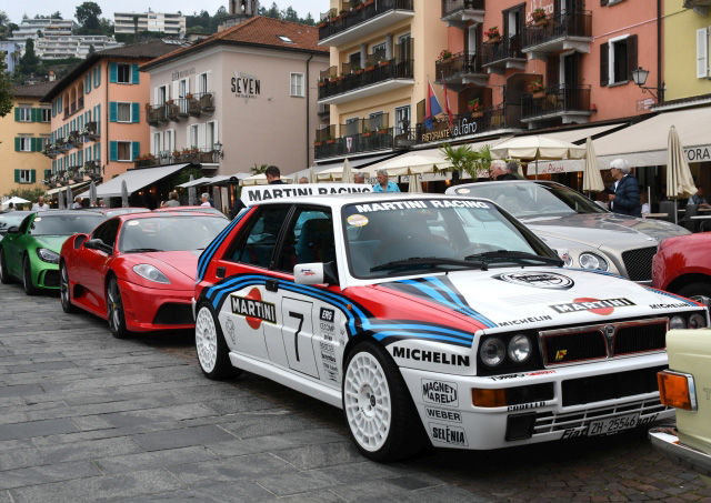 Supersport Wagen und Martini Racing Fahrzeuge stapeln sich an der Uferpromenade. Fotocredit: Streun roter ferrari- grüner AMG- Rollsroyce undMartini Racing Fahrzeuge parken an der uferpromenade in ascona