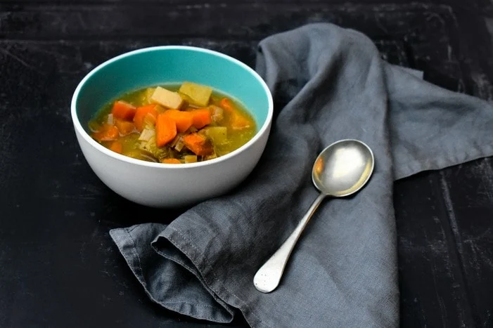 Scottish Slow Cooker Vegetable Soup in white bowl with grey napkin and soup spoon