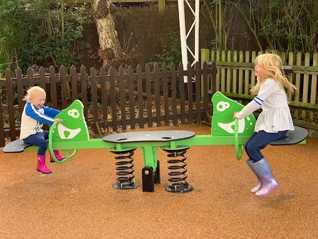 Two children bouncing up and down on a see saw