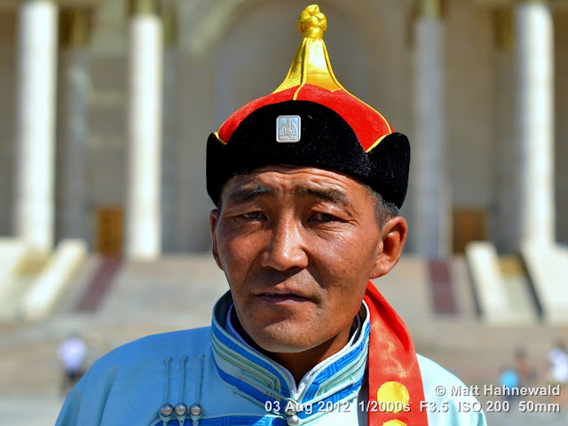 people, portrait, headshot, street portrait, Mongolia, Ulaanbaatar, Chinggis Khaan Square, Mongolian man, traditional Mongolian costume, traditional Mongolian hat, Mongolian deel