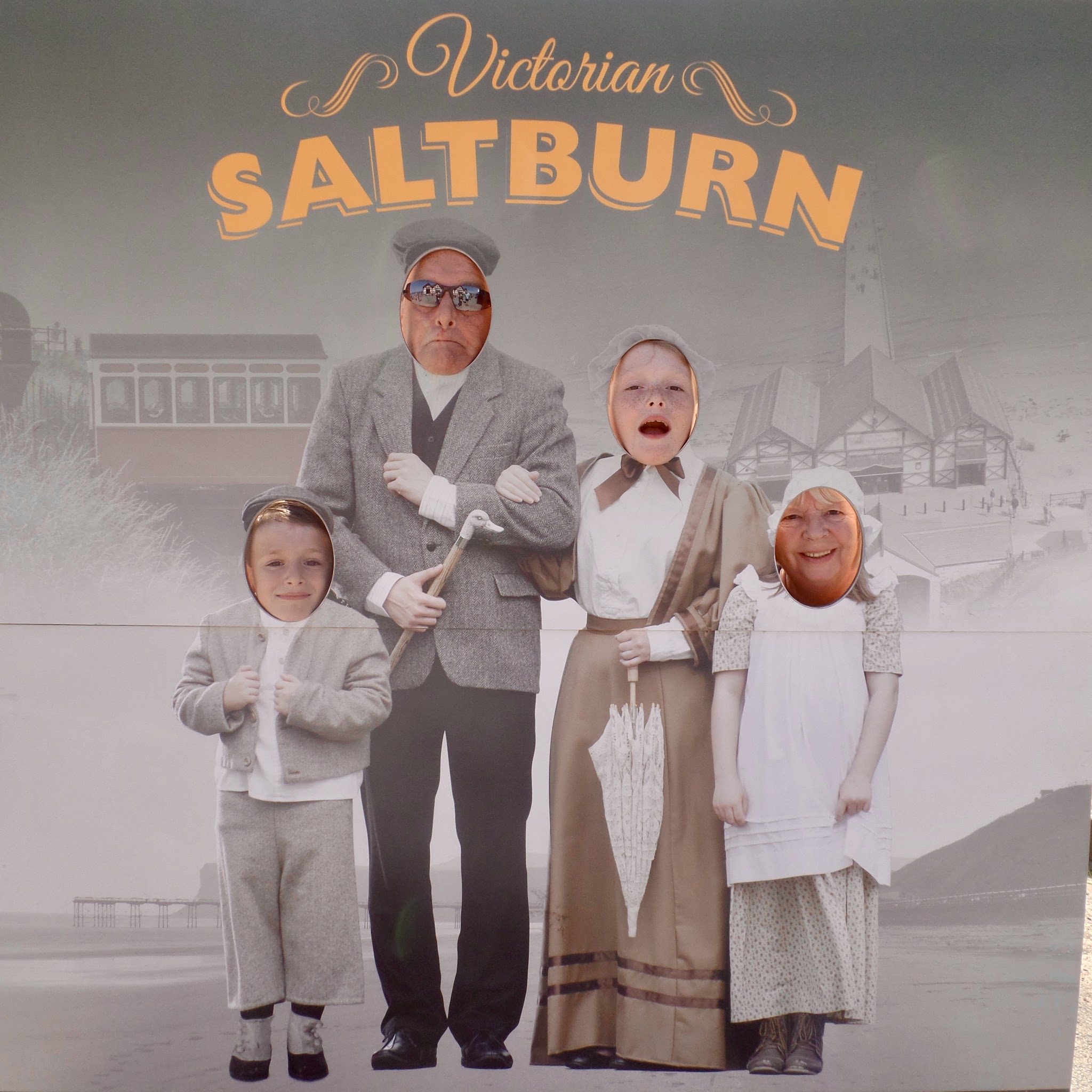 #PointShoot: A trip to Saltburn Family standing behind a board with face cuts outs. Board is people in Victorian dress