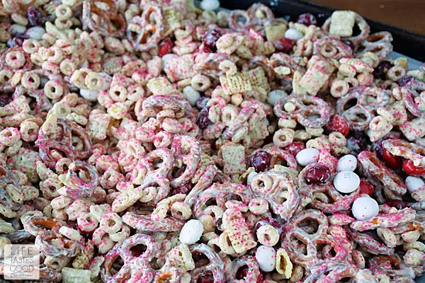 Valentine's Day Snack Mix is a delicious way to share the love with all of your favorite Valentines. This sweet snack mix is made with M&M's® Red Velvet candies, crispy cereal, crunchy pretzels, and salty peanuts all covered in creamilicious white chocolate and sparkly pink sprinkles! #RedVelvetLove #ad