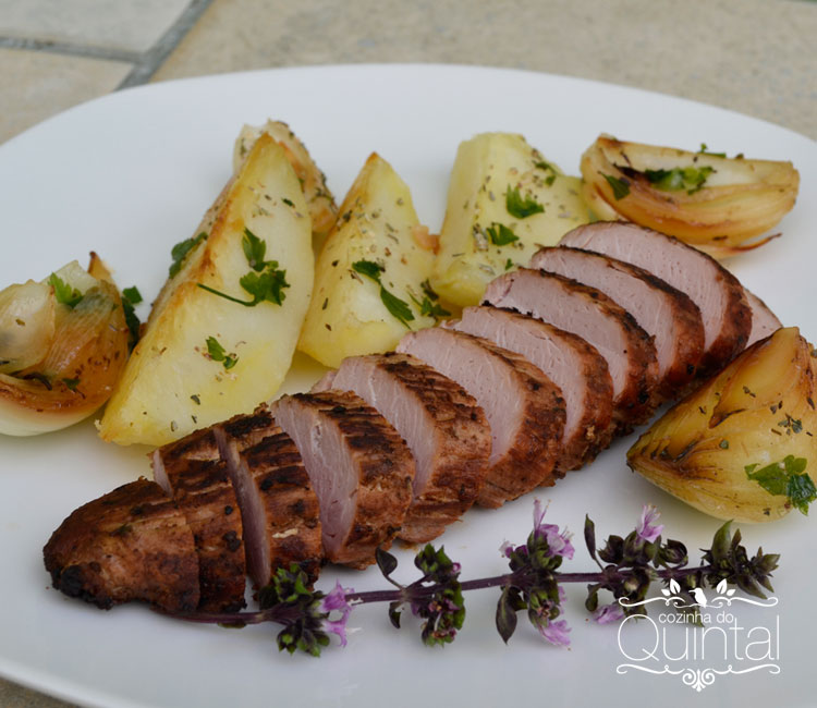 Filé mignon de porco assado com batatas, cebolas e ervas frescas na Cozinha do Quintal