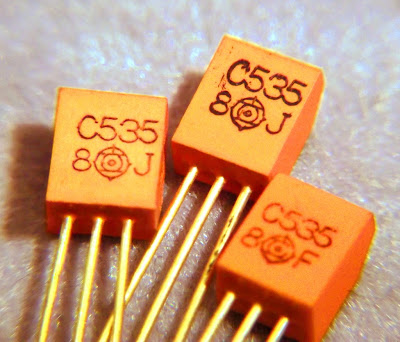 Macro image of 2SC535 Hitachi transisors with orange cases and gold legs