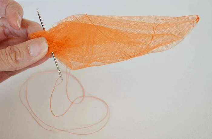 Making a carrot shape out of tulle and securing the top with thread